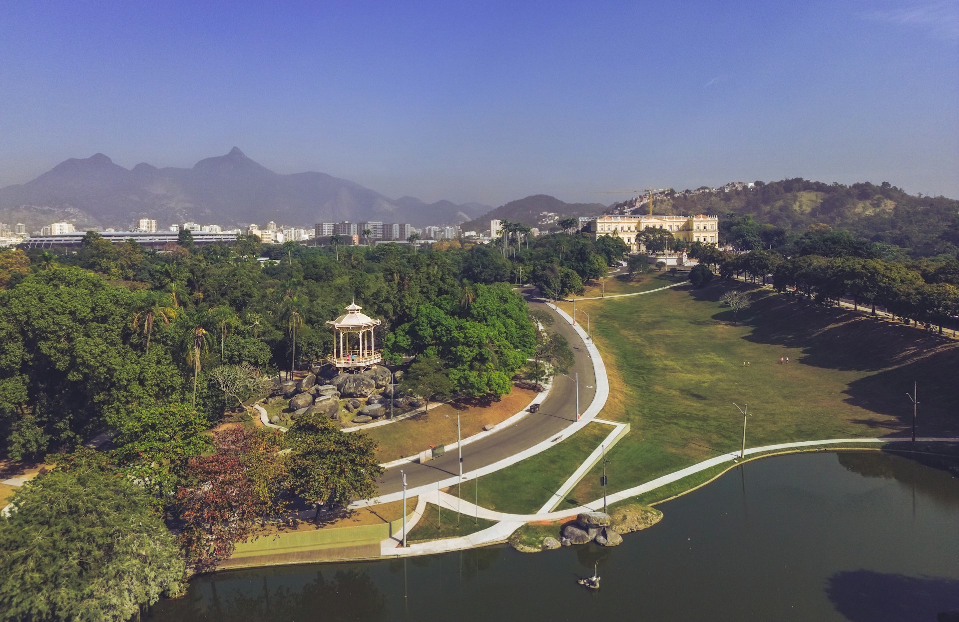 an aerial view of a park with mountains in the background